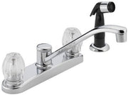 Chrome two-handle kitchen faucet with curved spout, side sprayer, and clear knob handles.