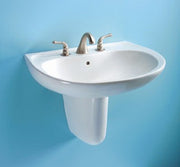 White oval wall-mounted bathroom sink with chrome faucet and handles against blue background.