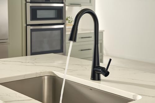 Matte black high-arc kitchen faucet with pulldown sprayer and motion sensor mounted on white countertop above stainless steel