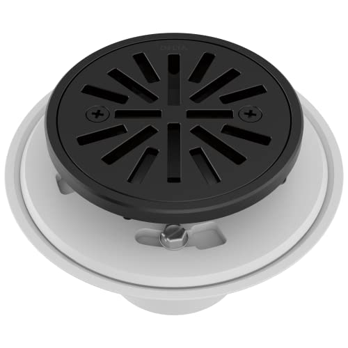 Round matte black shower drain with radial slot pattern and white trim ring for tile installation.