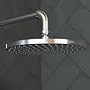 Chrome round showerhead with single spray jet and curved arm mounted on dark tiled wall.
