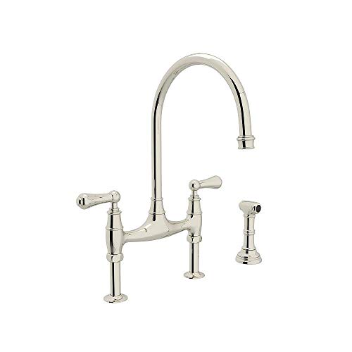 Polished nickel bridge kitchen faucet with high arched spout, two handles, and matching side spray attachment.
