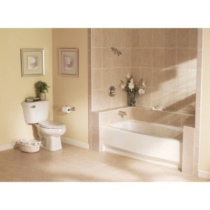 Brushed nickel toilet tank lever handle mounted on beige bathroom wall next to toilet.