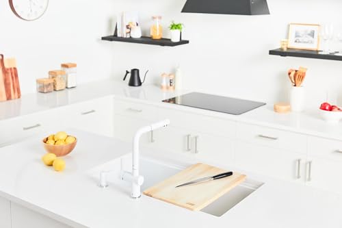 Black granite undermount kitchen sink installed in white countertop with white faucet and surrounding cabinetry.