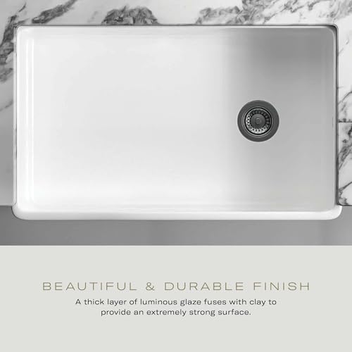 White fireclay undermount sink with single drain outlet and rounded corners, viewed from above.