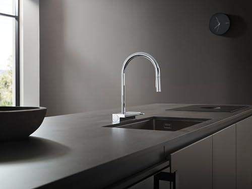 Polished nickel high-arc kitchen faucet with pull-down spray head mounted on dark countertop sink.