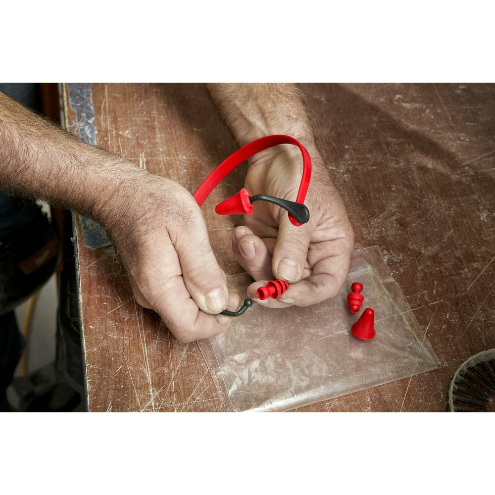 Red flanged ear plugs with black connecting cord held in hand, showing multiple plugs and connector loop.