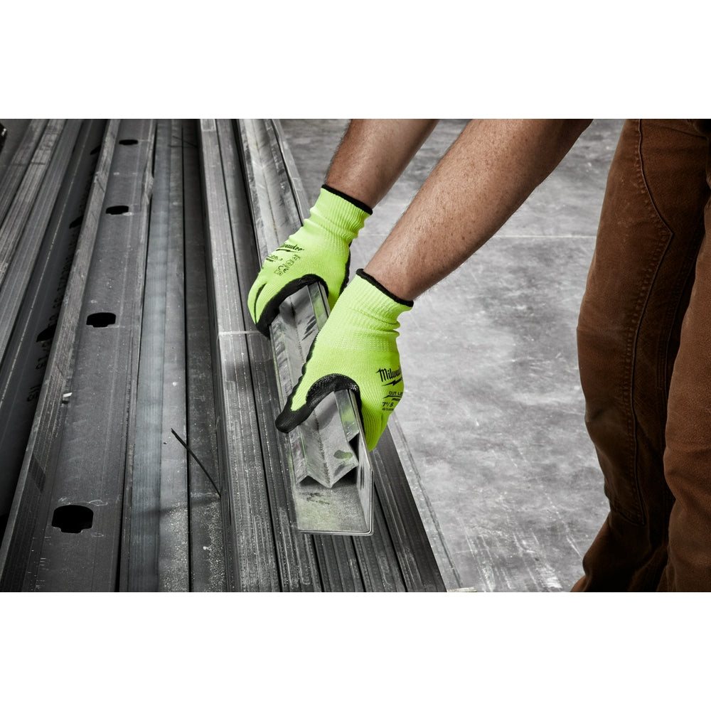 Bright yellow-green work gloves with black trim worn while handling metal sheet material.