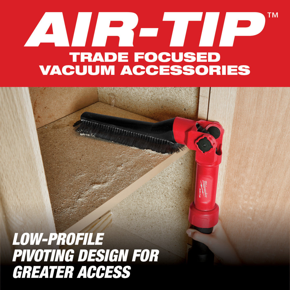 Red and black low-profile pivoting brush tool with bristles, shown cleaning carpet corner baseboards.