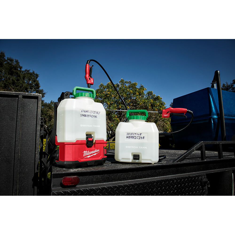 Red and black Milwaukee sprayer wand with curved nozzle attached to white tank with green cap.