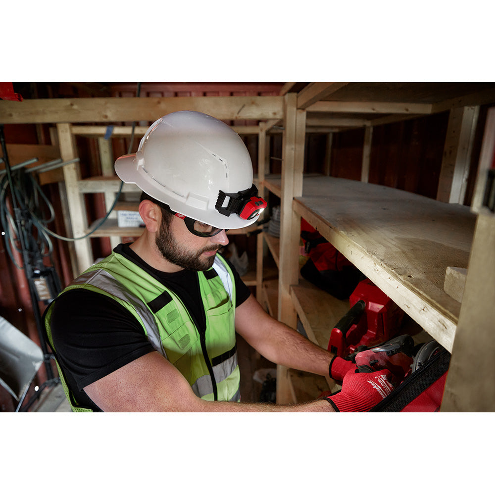 Black full brim hard hat with vented crown and red suspension adjustment knob worn on construction site.