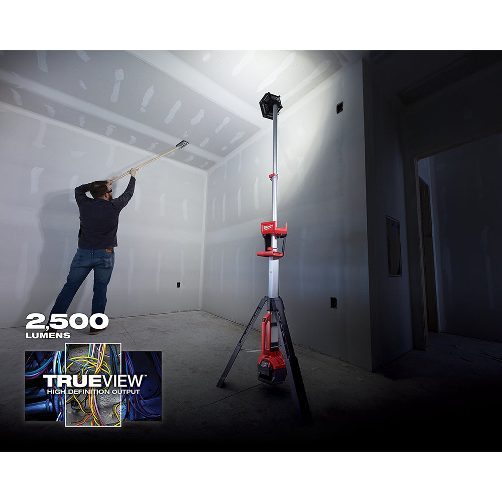 Red and black tower light with telescoping pole mounted on tripod stand, illuminating an unfinished interior space.