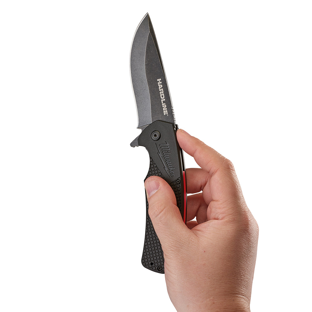 Black pocket knife with gray smooth blade held in open position in a hand.