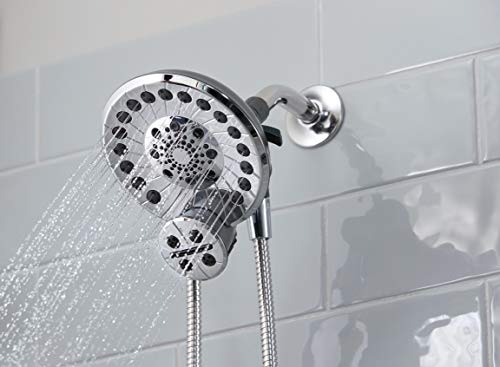 Chrome shower head with multiple spray holes mounted on wall with flexible hose attachment.