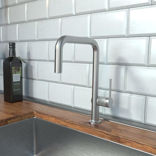 Steel optic U-shaped kitchen faucet with single spray head mounted on countertop against white subway tile backsplash.