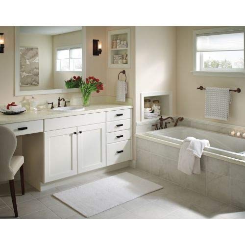Venetian bronze metal lever handles mounted on a roman tub deck in a bathroom setting.