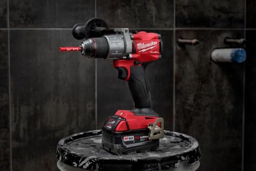 Red and black Milwaukee cordless drill with diamond grit hole saw bit attached, displayed with battery on dark tile backgroun