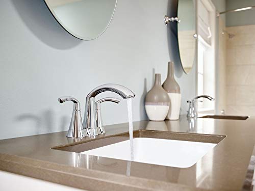 Chrome two-handle bathroom faucet with curved spout installed on bathroom vanity sink.