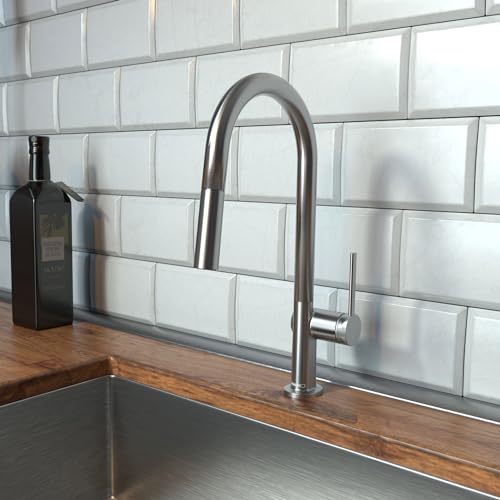 Steel Optic high-arc kitchen faucet with pull-down spray mounted on countertop against subway tile backsplash.