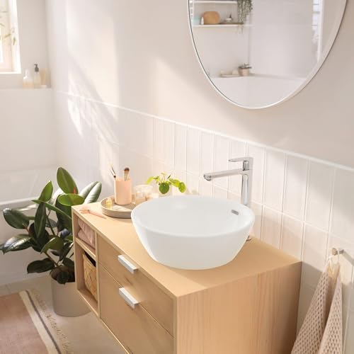 Chrome single-hole bathroom faucet with curved spout mounted on white vessel sink in bathroom vanity.