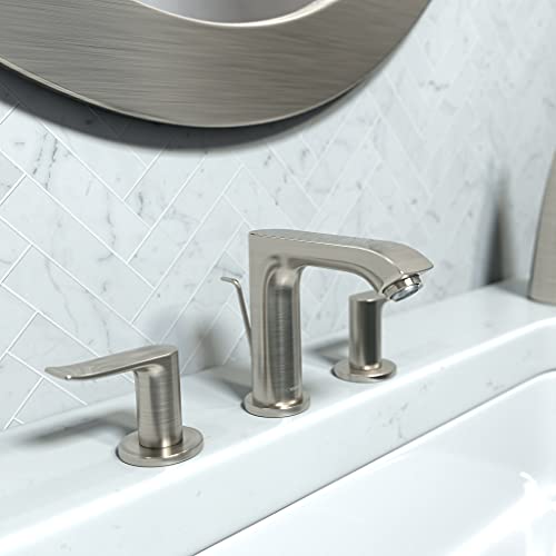 Brushed nickel widespread bathroom faucet with curved center spout and lever handles on white sink.