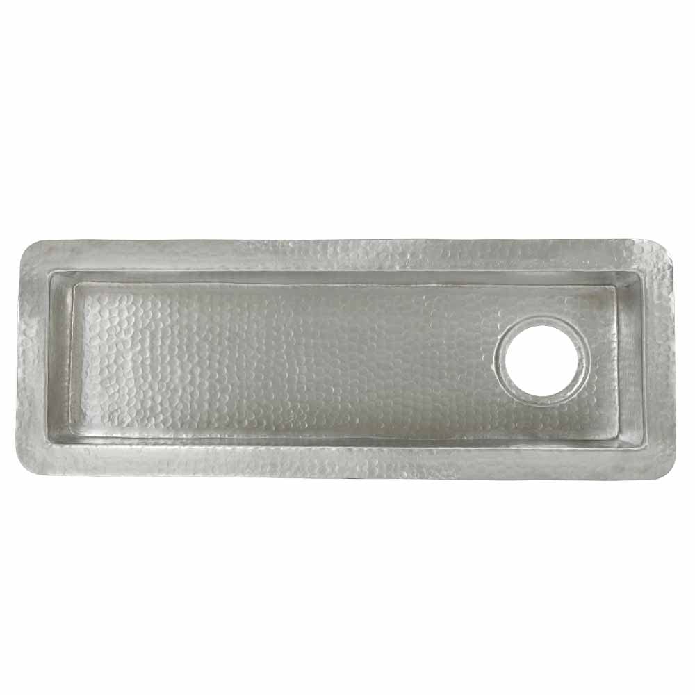 Hammered copper rectangular bar sink with single drain hole on right side, viewed from above.