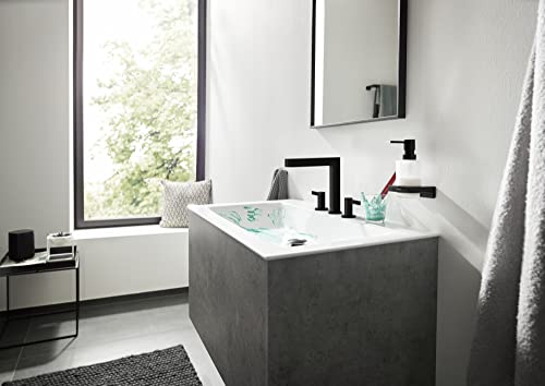 Matte black wide-spread bathroom faucet with angular handles installed on concrete vanity sink.