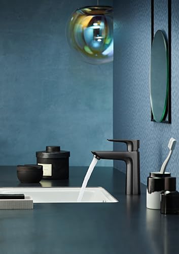 Black chrome single-hole faucet with curved spout over white sink basin on blue bathroom wall.