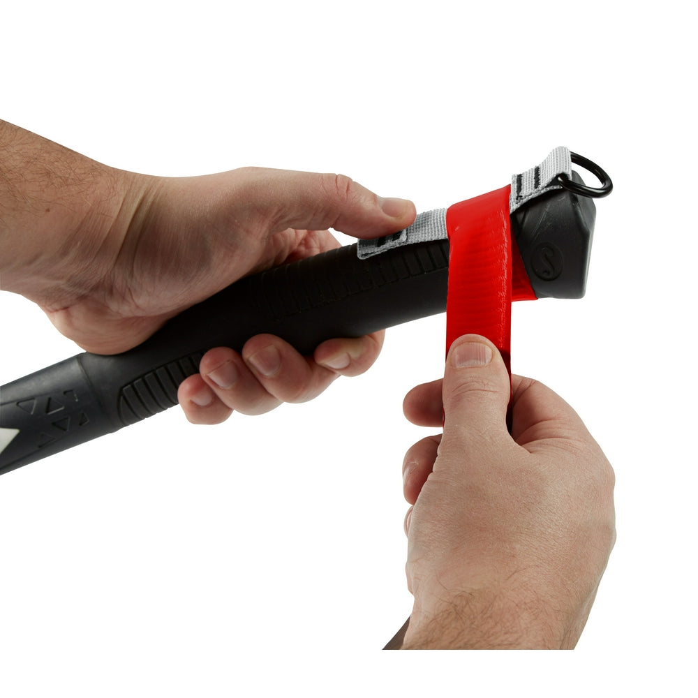 Red and black self-adhering tape dispenser with black handle held in hands, showing tape being pulled from the roll.
