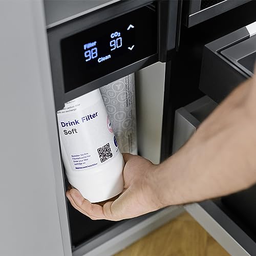 White cylindrical filter cartridge labeled "Drink Filter Soft" being held in a built-in water system dispenser.