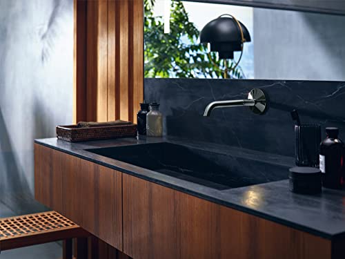 Chrome wall-mounted single-handle faucet with curved spout installed above black countertop sink.