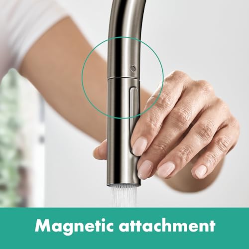 Brushed black chrome high-arc kitchen faucet with pull-down sprayer head held in hand, showing magnetic attachment feature.