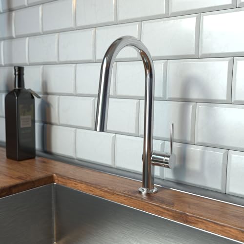 Chrome high-arc kitchen faucet with pull-down spray head mounted on wooden countertop against white subway tile backsplash.