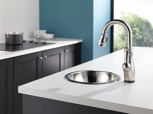 Chrome single-handle pull-down faucet with gooseneck spout installed above round prep sink in kitchen.