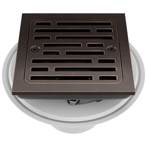 Square shower drain with Venetian bronze grate and slotted pattern design, mounted on white collar base.
