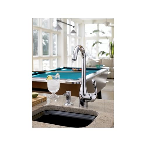 Chrome single-lever bar faucet with curved spout installed at kitchen sink counter.