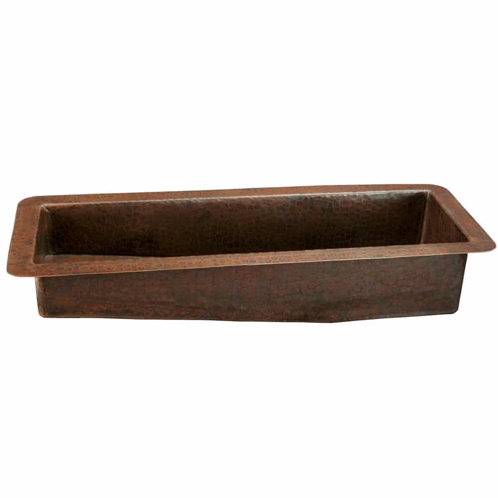 Hammered copper rectangular bar sink with sloped sides and textured surface finish.