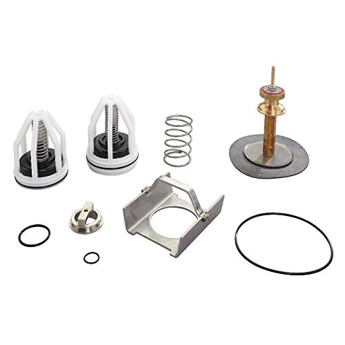 Watts RPZ repair kit containing white cartridge caps, internal springs, metal bracket, brass valve stem, rubber seals, and wa