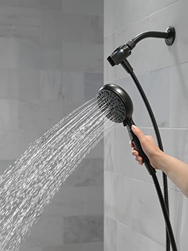Matte black handheld shower head with curved hose attached to wall mount, dispensing water spray.