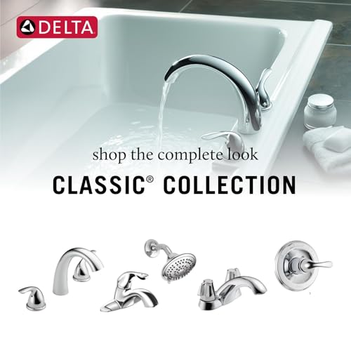 Chrome roman tub faucet with curved spout and two knob handles installed on white bathtub.