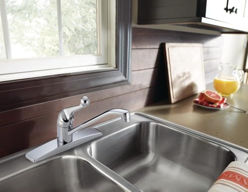 Chrome single-handle kitchen faucet with lever control mounted on stainless steel double basin sink.