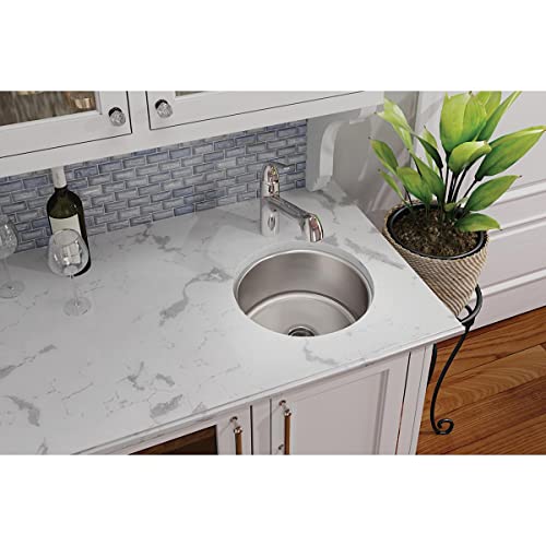 Stainless steel round single bowl undermount sink installed in white marble countertop.