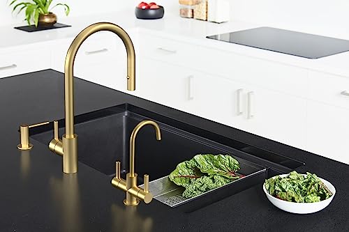Gold-finish pull-down kitchen faucet with single handle over black sink basin in modern kitchen setting.