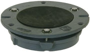 Cast iron toilet flange with black test cap and mounting holes on gray circular base.