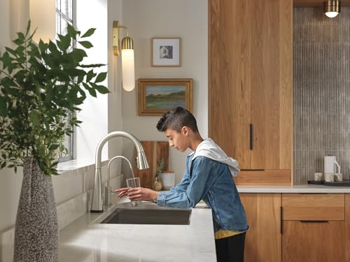 Stainless steel pull-down beverage faucet with curved spout installed at kitchen sink.