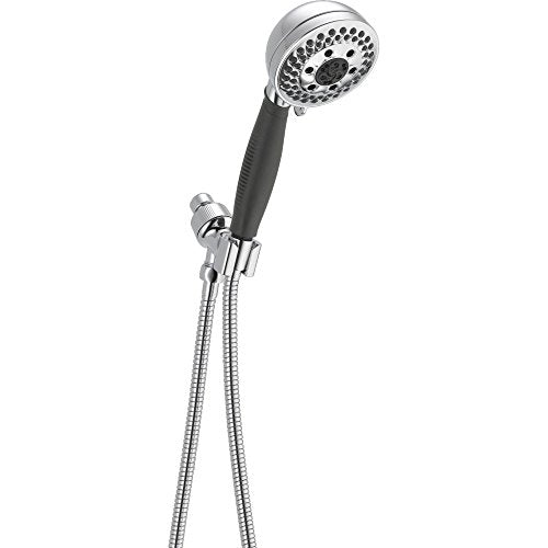 Chrome handheld shower head with black grip handle and dual flexible metal hoses on wall bracket.