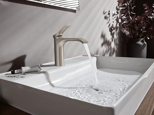 Brushed nickel single-hole bathroom faucet with curved spout mounted on white rectangular sink basin with running water.
