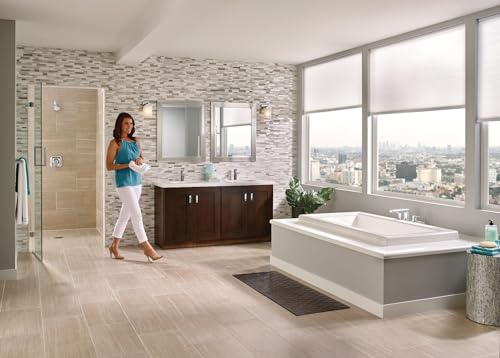 Chrome single-handle faucet mounted on dark vanity in modern bathroom with white soaking tub and glass shower enclosure.