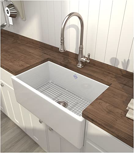 Polished nickel pull-down kitchen faucet with arched spout mounted above white farmhouse sink on wood countertop.