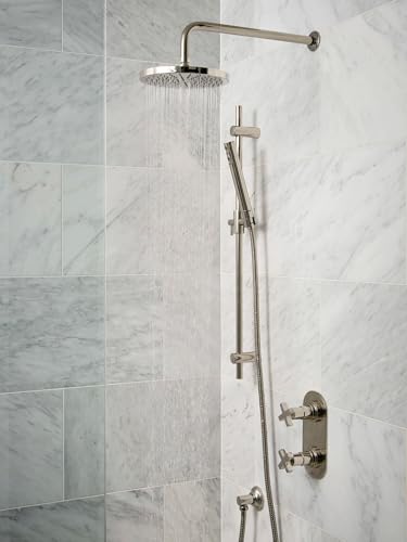 Unlacquered brass rain showerhead with 8-inch diameter mounted on marble tile wall above handheld spray fixture.